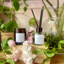 College Green Painswick Rose reed diffuser and soy wax candle on bedside cabinet with roses