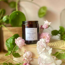 College Green amber glass jar of Painswick Rose soy wax candle with fresh roses