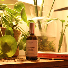 A bottle of College Green Sleep Easy pillow spray on a bedside cabinet