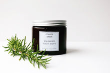 Amber glass jar of Warming foot soak with sprig of rosemary 
