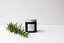 Amber glass jar of Warming foot soak with sprig of rosemary 